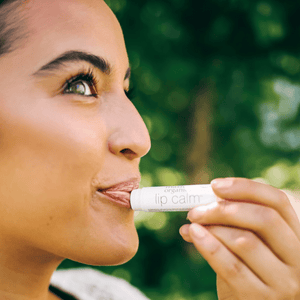 woman putting lip balm on