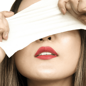 woman holding cloth over eyes