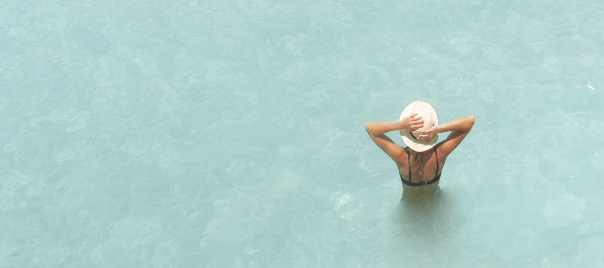 Woman in a sun hat standing in the sea