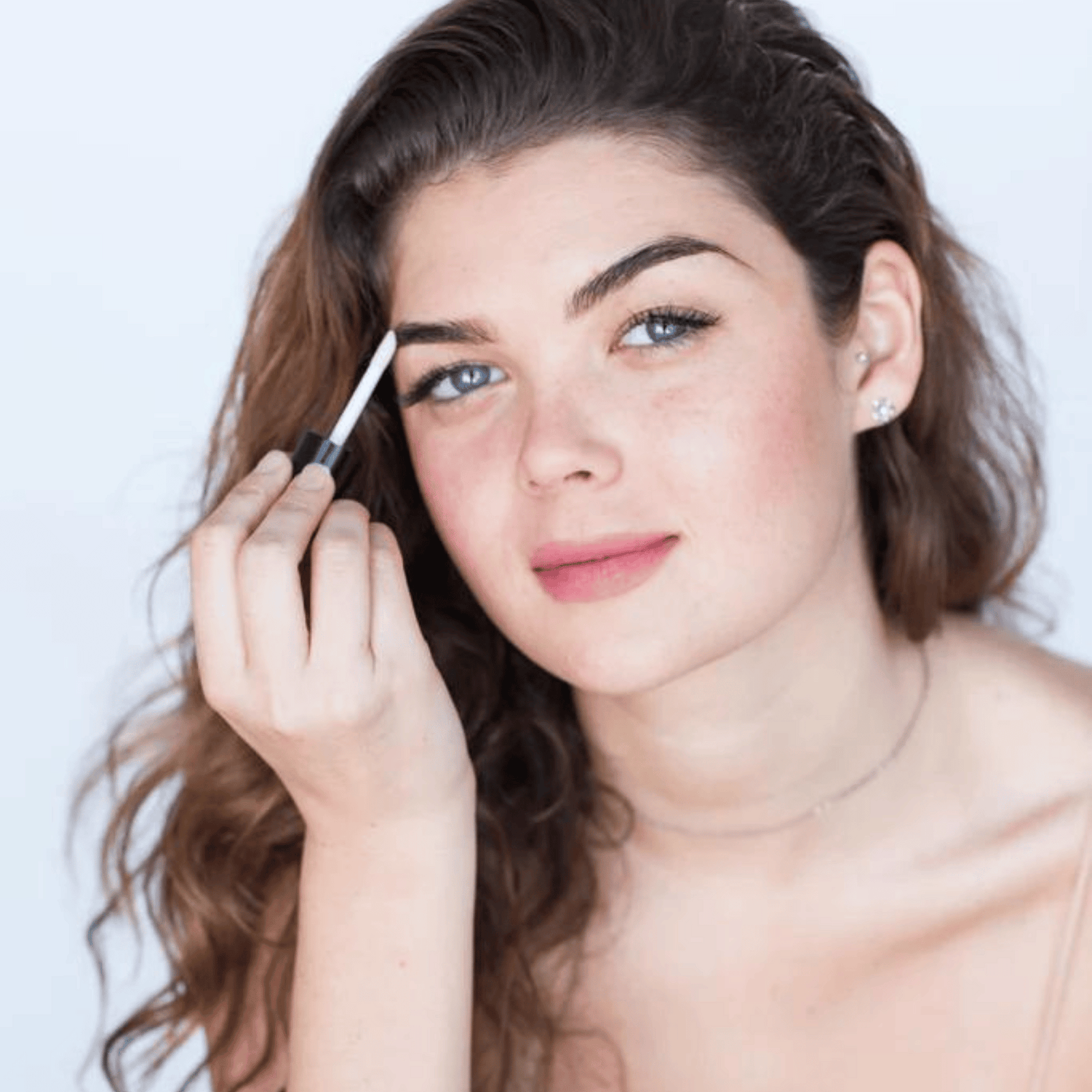 woman applying brow oil