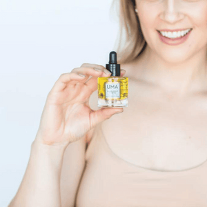 woman holding neck oil bottle