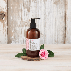body lotion with a rose on wood tray