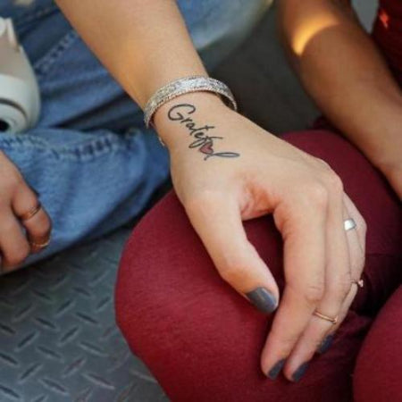 Think Positive' wrist tattoo on Camila Valles.